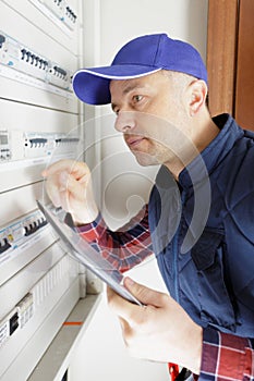 electrician at work installing electric line distribution fuseboard