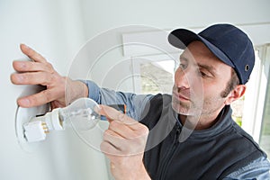 electrician at work - installing lamp on wall