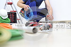 Electrician at work with nippers in hand cut the electric cable, install electric circuits for electrical wiring