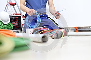 Electrician at work with nippers in hand cut the electric cable, install electric circuits for electrical wiring