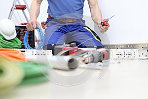 Electrician at work with nippers in hand cut the electric cable, install electric circuits, electrical wiring.