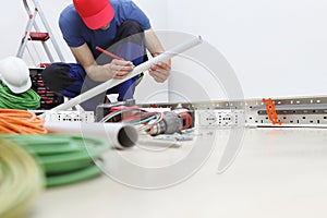 Electricista sobre el lápiz en la mano medidas el plastico tubo sobre el atropellar eléctrico sobre el enchufes instalar eléctrico 