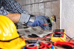 Electrician at work with safety equipment on a residential electrical system. Electricity