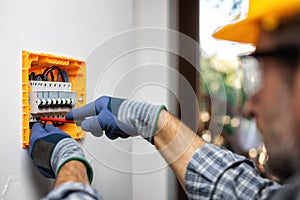 Electrician at work with safety equipment on a residential electrical system. Electricity