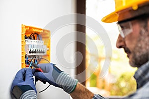 Electrician at work with safety equipment on a residential electrical system. Electricity