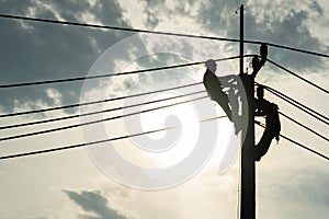 Electrician worker climbing electric power pole to repair the damaged power cable line problems after the storm. Power line