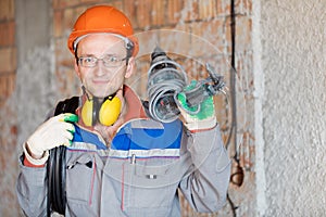 Electrician worker with electrical cable and drill tool