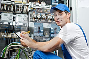 electrician worker inspecting equipment and electricity meter