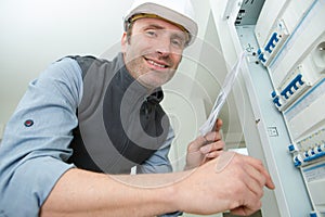 electrician worker next to fuse board