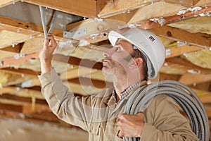 Electrician working with cables in celing