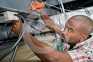 Electrician working on ceiling wiring