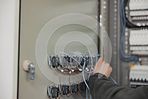 electrician working on electric panel, closeup of hands