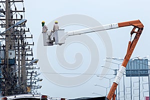 Electrician working on electric pole with  bucket hydraulic lifting platform