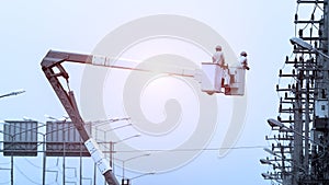 Electrician working on electric pole with  bucket hydraulic lifting platform