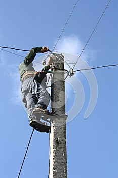 Electrician working on electric power pole