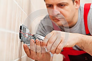 Electrician working on electrical wall fixture