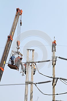 Electrician working at height by connect a high voltage wire.