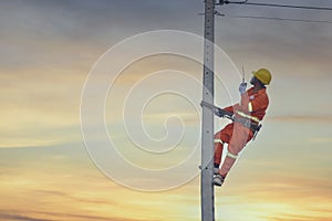 An electrician is working on a pole.Linemen