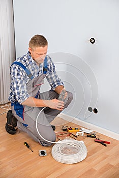 Electrician working with wire with plier photo