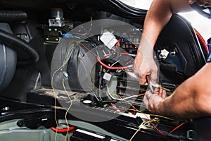 Electrician works with electric block in car