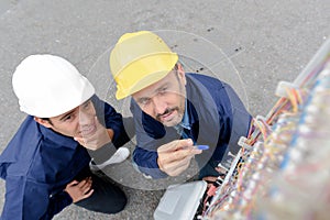 electricians checking control panel outdoors