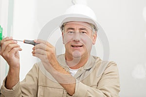 Electricians hands assembles standard bipolar wall socket