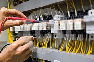 Electricians hands testing current  electric in control panel