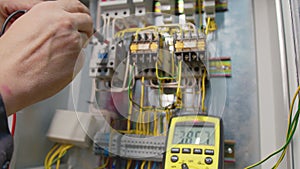 Electricians hands testing current electric in control panel. Electrician engineer work tester measuring voltage and