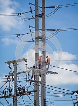 Electricians is repairing high voltage wires on electric power pole