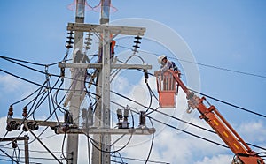 Electricians is repairing high voltage wires on electric power pole