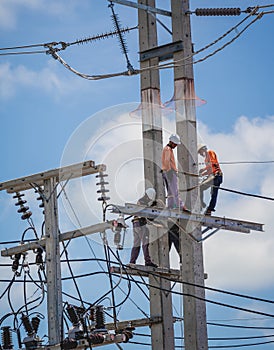 Electricians is repairing high voltage wires on electric power pole