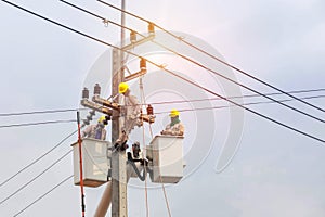 Electricians repairing wire of the power line with bucket hydraulic lifting platform