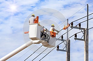 Electricians repairing wire of the power line with bucket hydraulic lifting platform