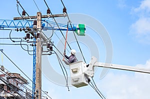 Electricians repairing wire of the power line with bucket hydraulic lifting platform