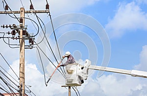 Electricians repairing wire of the power line with bucket hydraulic lifting platform