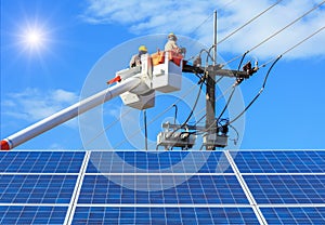 Electricians repairing wire of the power line on bucket hydraulic lifting platform with photovoltaics in solar power station photo