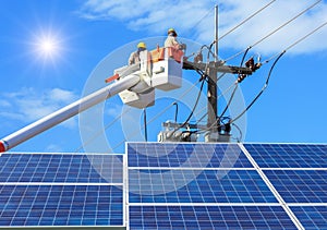 Electricians repairing wire of the power line on bucket hydraulic lifting platform with photovoltaics in solar power station