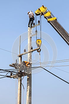 Electricians repairing wire of the power line with crane .