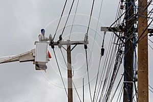 electricians repairing wire of the power line on electric power pole