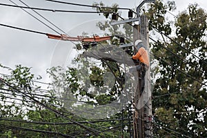 electricians repairing wire of the power line on electric power pole