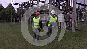 Electricians talking in electrical substation