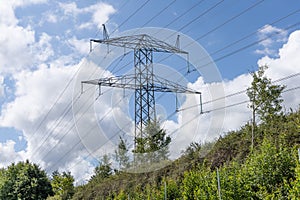 Electricity concept. Electricity concept. High voltage power line pylons, electrical tower on a green field with blue sky