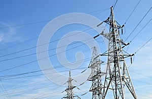 Electricity concept, high voltage power lines. High voltage electric transmission pylon silhouetted tower.