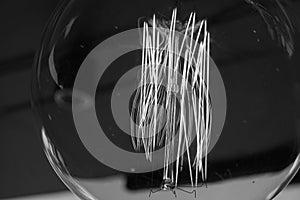 Electricity current inside a retro crystal clear light bulb.