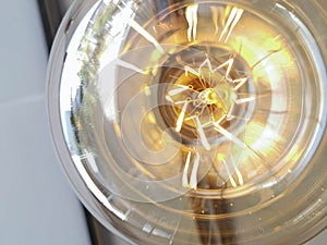 Electricity current inside a retro crystal clear light bulb.