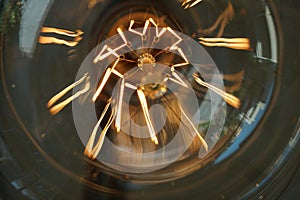 Electricity current inside a retro crystal clear light bulb.