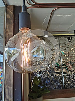 Electricity current inside a retro crystal clear light bulb.