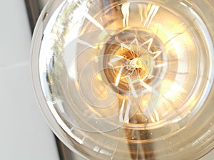 Electricity current inside a retro crystal clear light bulb.