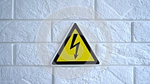 Electricity danger a sign on yellow background. A danger sign hangs on a wall. 4k stock footage.