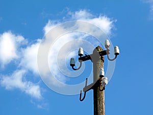 Electricity distribution wooden post with no cables under blue sky